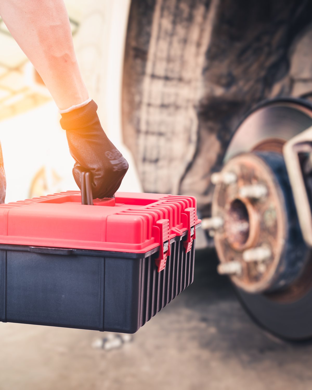 A battery tech working at the front of a car